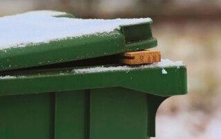 stukje hout tussen deksel en groene Kliko