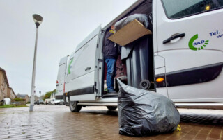 Busje van de RAD met op de voorgrond een vuilniszak.