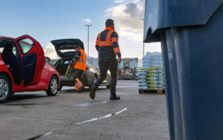 Medewerkers RAD delen zakken compost uit bij het ophaalpunt naast de milieustraat in Westmaas