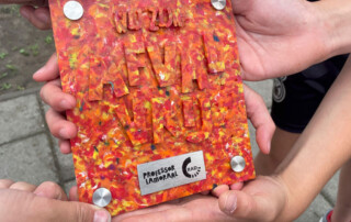 Kinderhanden houden bordje 'Wij zijn afvalvrij!' van gerecycled plastic vast