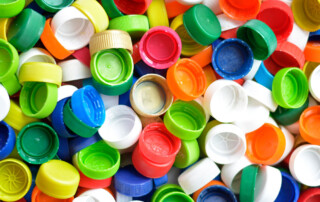 gekleurde plastic doppen van flesjes en drinkpakken