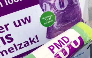 rol pmd-zakken bij bord boven krat met rollen pmd-zakken